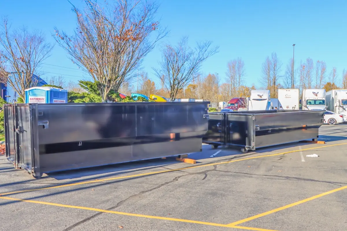 Professional dumpster rental service with roll-off container on residential driveway in Highland